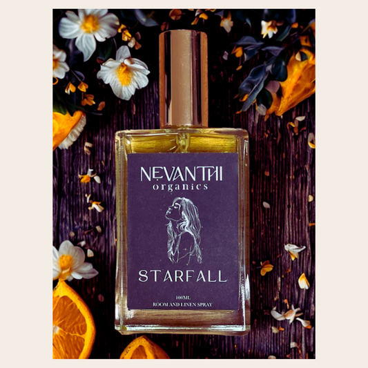 Nevanthi Organics Starfall room and linen spray bottle with decorative flowers and oranges on a dark background