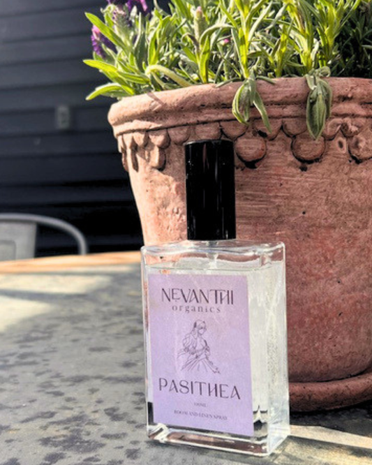 Pasithea room and linen spray by Nevanthi Organics — 100ml luxury lavender rosewood and bergamot home fragrance styled outdoors with terracotta pot and lavender plant
